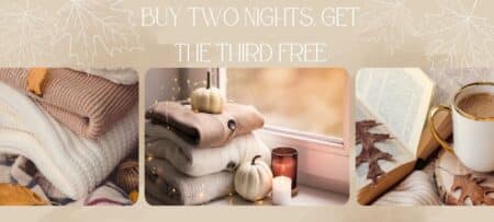 "Promotional banner with a cozy autumn theme featuring soft folded sweaters, a window with small white pumpkins and candles, and a book with a cup of coffee on a fall leaf-strewn surface. The text reads: 'Buy Two Nights, Get the Third Free.'"