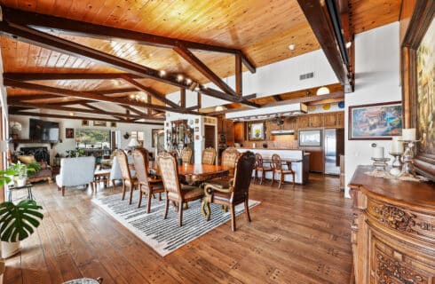 Dining room area with wood furniture, dining table and kitchen in the background
