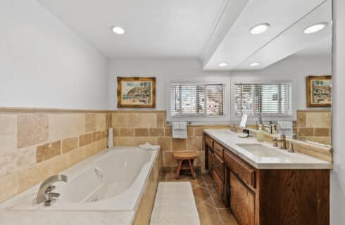 Dual vanity with tile and jetted tub with artwork
