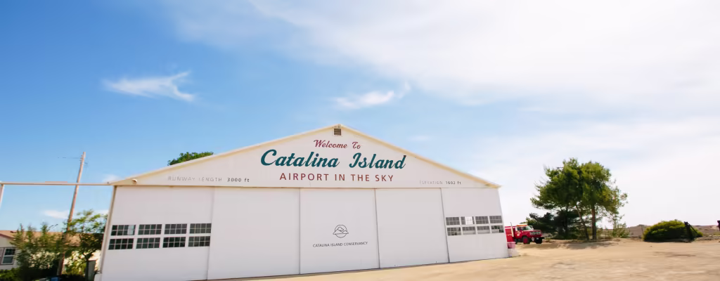 airport in the sky hanger white building with writing and fire truck on the side