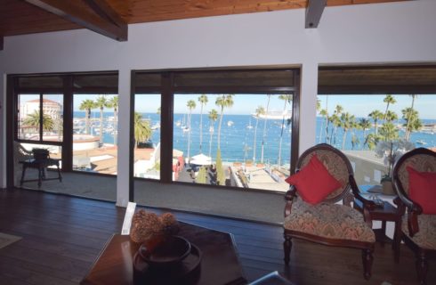 Large meeting room with wood flooring and dark wood furniture overlooking view of ocean marina