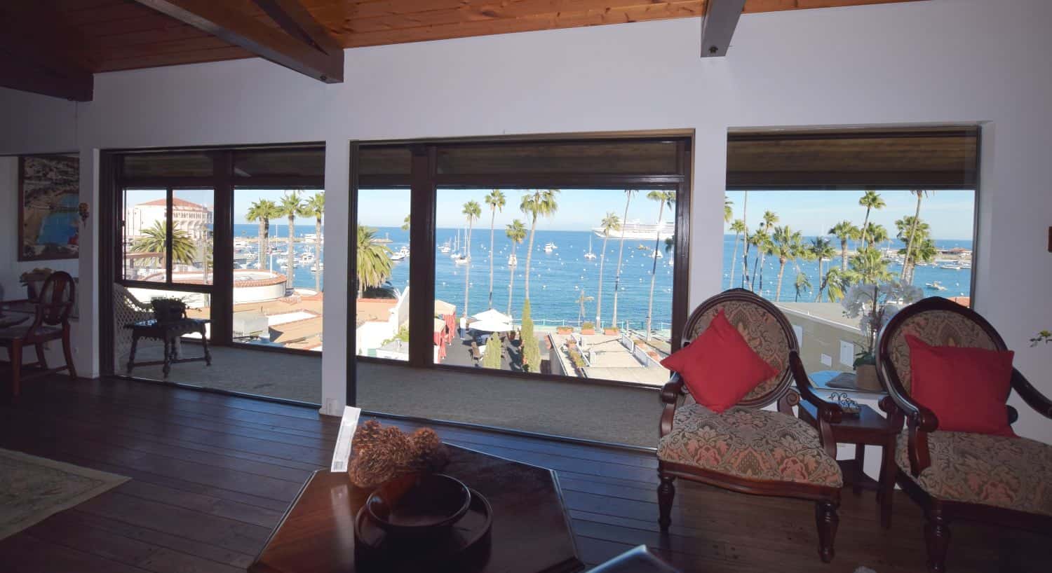 Large meeting room with wood flooring and dark wood furniture overlooking view of ocean marina
